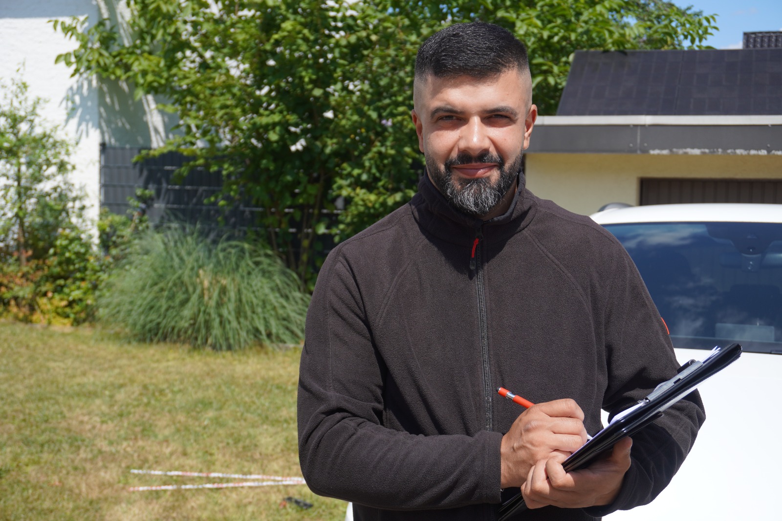 Mahmut Temin mit Gutachtenprotokoll am Fahrzeug